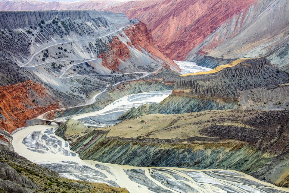 Devekere li quntarên çiyayê Tian Shan ê li Çînê, çemek li dû riya zixûrê/kanyonê diherike. Di serdema çêbûna tebeqeyên rûerdê de kevirên rengîn beş bi beş xuya dikin. Tevî av û bageran rûyê çiyayê ciwan diçilmise.